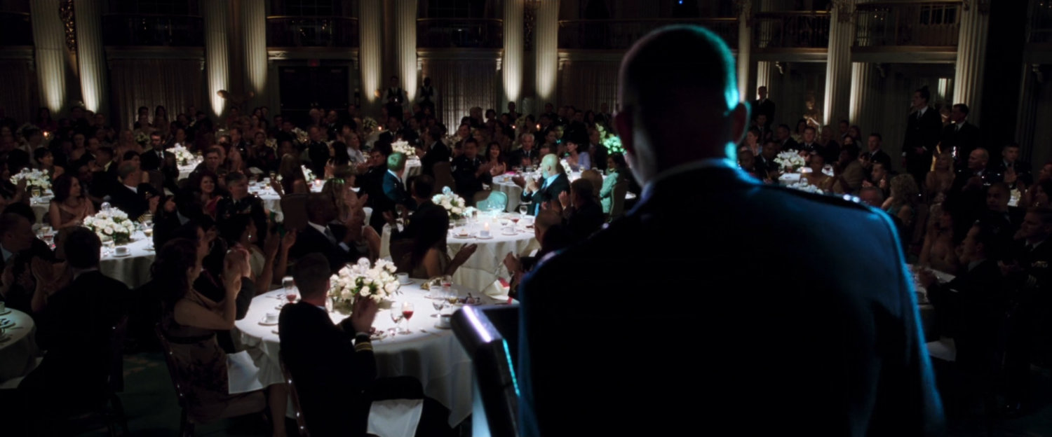 Colonel Rhodes give a speech at an event in  a ballroom.