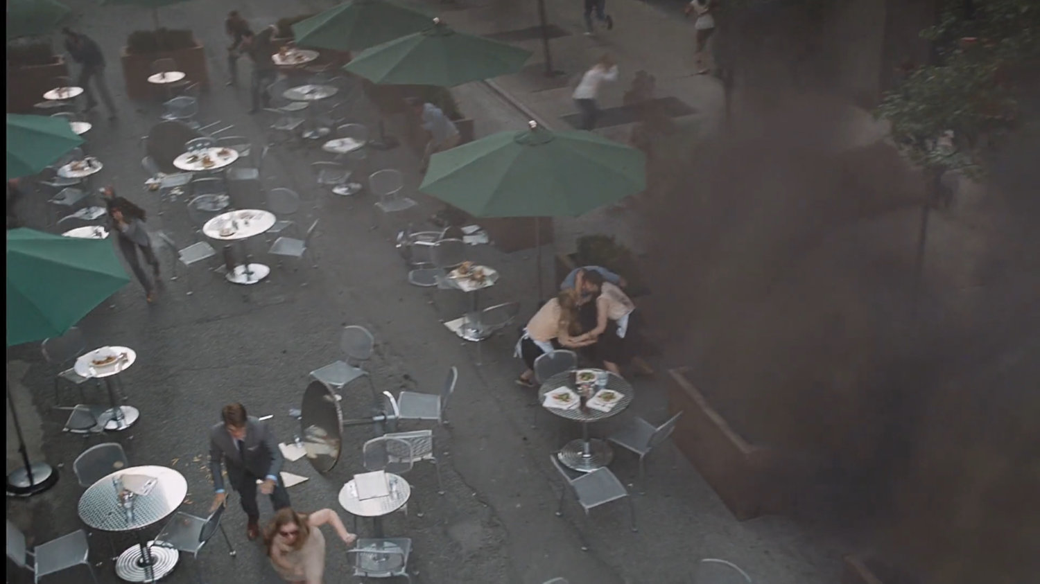 High angle view of people fleeing an outdoor cafe.