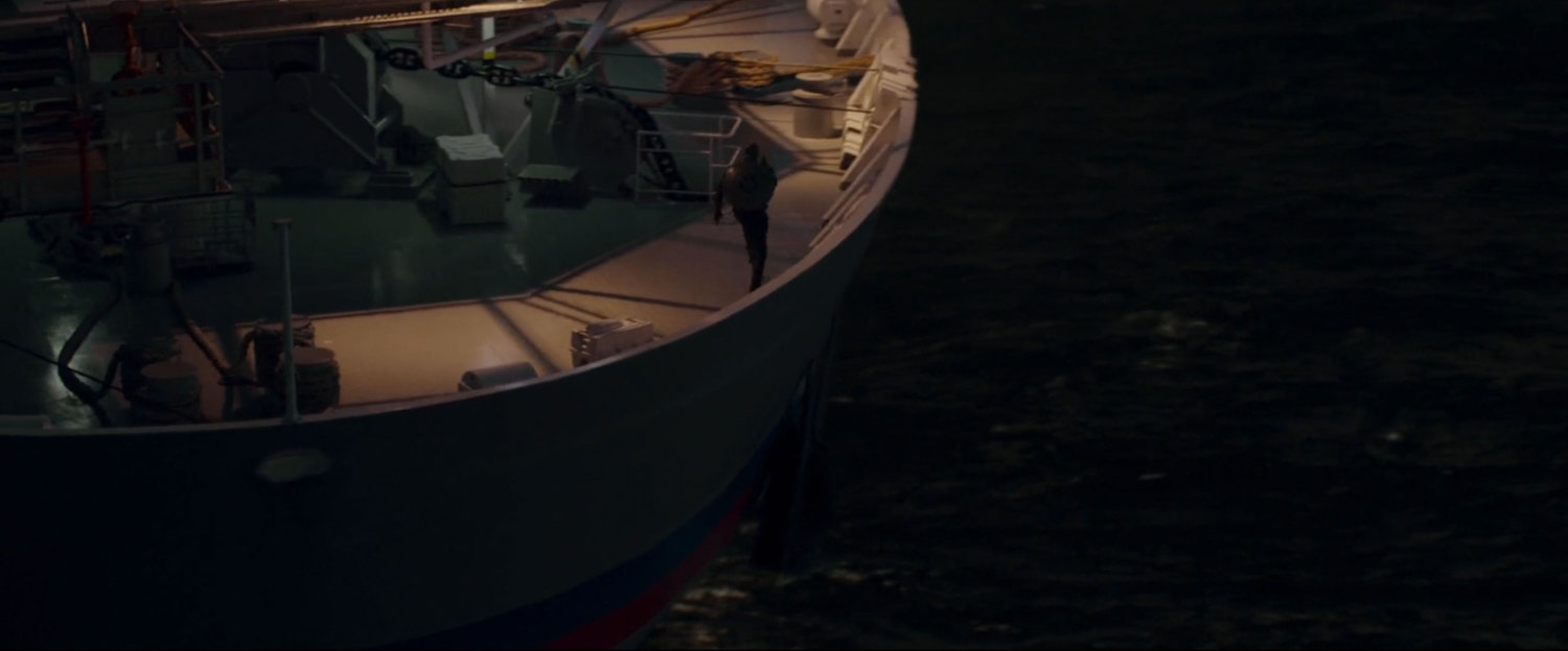 Man walking on stern of boat.