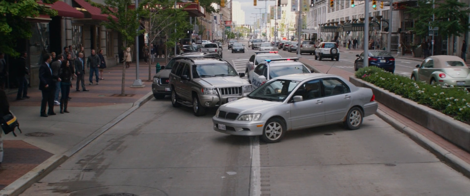 Stopped cars in middle of city street.