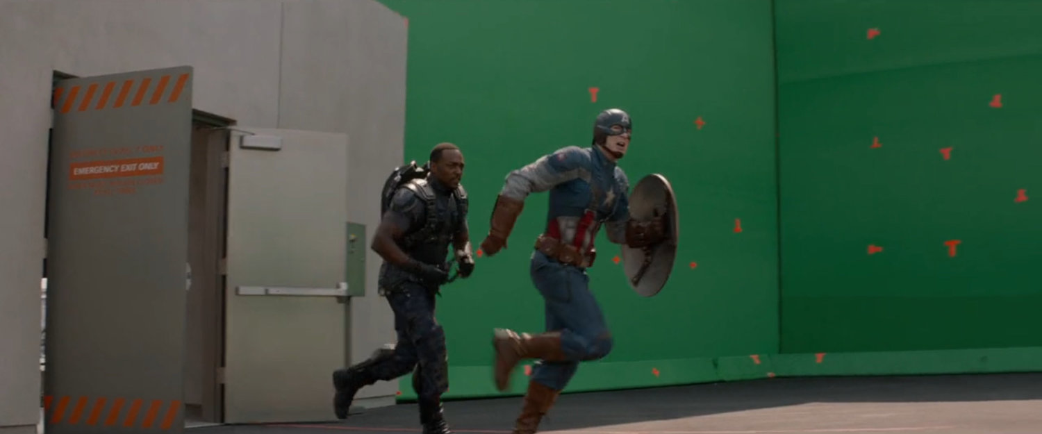Behind the scenes image of Anthony Mackie and Chris Evans in front of green screen.