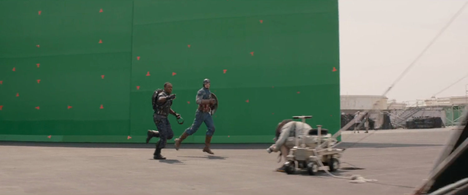 Behind the scenes image of Anthony Mackie and Chris Evans in front of green screen.