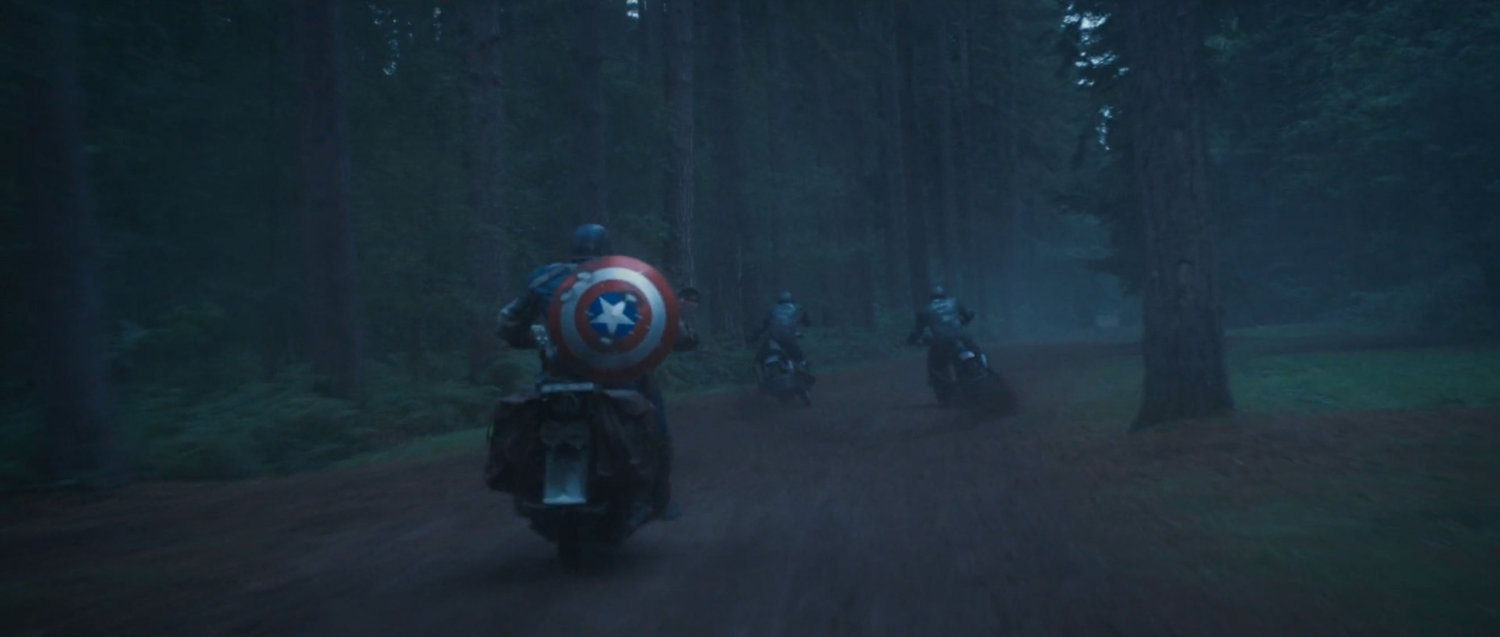 Captain America chases two HYDRA soldiers on motorcycles through the woods.