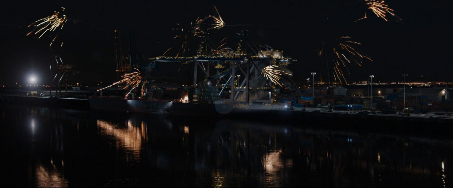 Nighttime view of oil refinery with fireworks going off.
