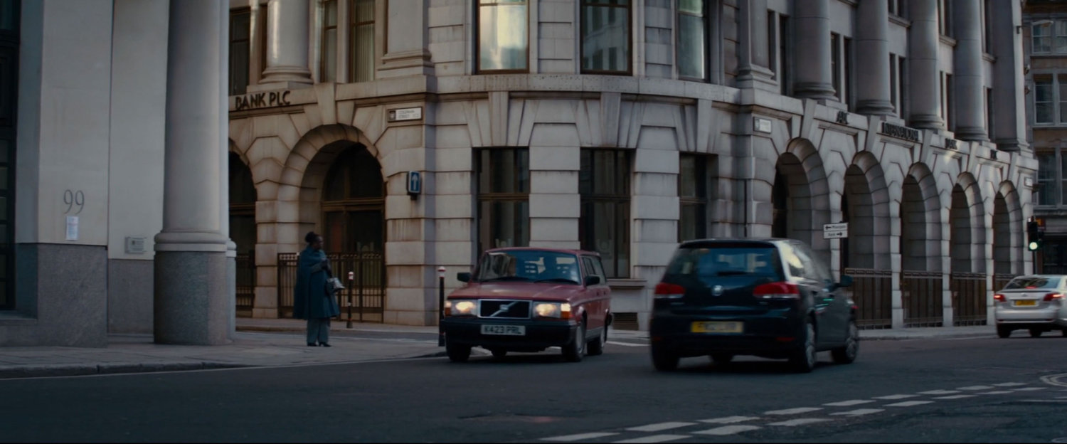 Red car turns corner in London.