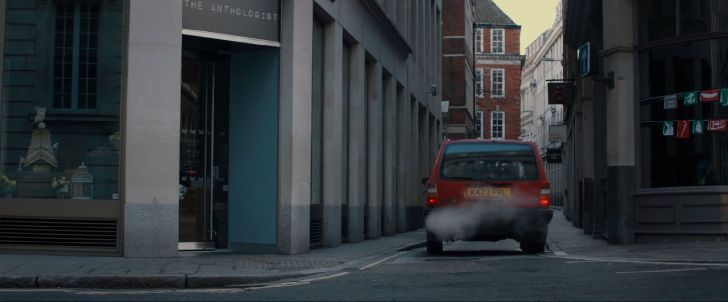 A red car drive into an alley.