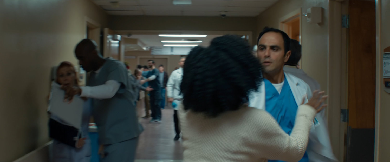 Monica Rambeau talking to a doctor in a crowded hospital corridor.