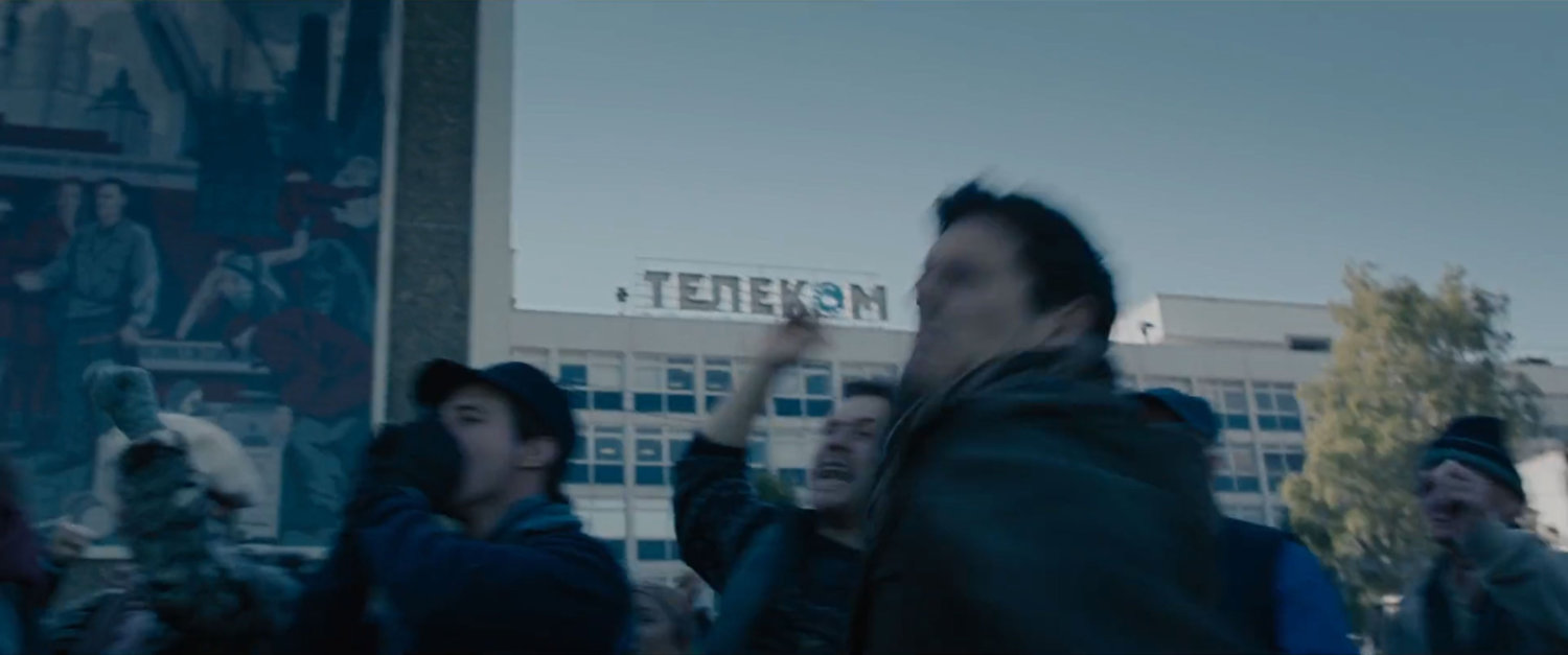 Civilians in front of a large apartment building.