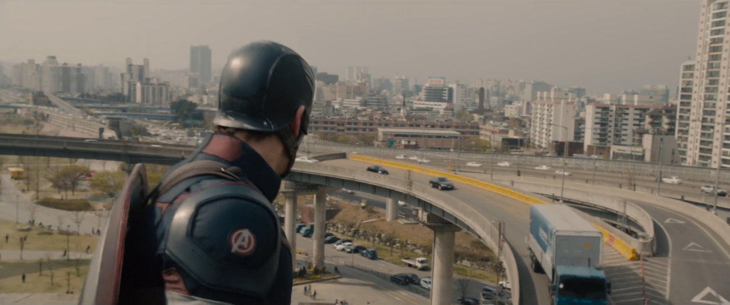 Captain America looking at traffic on bridge.