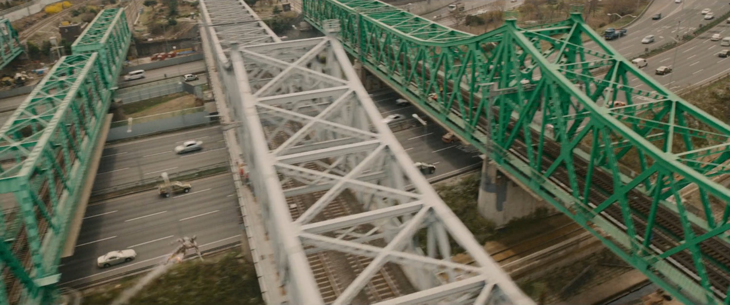 Aerial view of train bridges crossing expressway.
