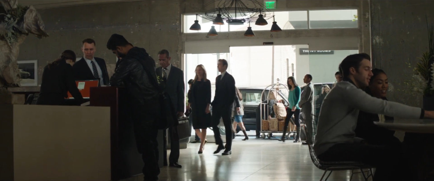 Sharon Carter and Steve Rogers enter a busy hotel lobby.