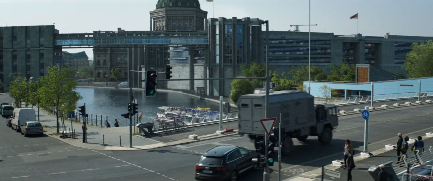 An armored truck turns right on a Berlin street.