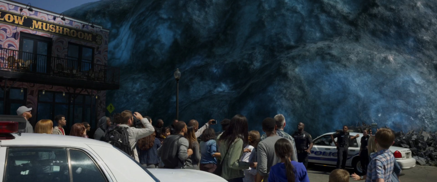 A giant alien spore towers over a crowd in a parking lot.