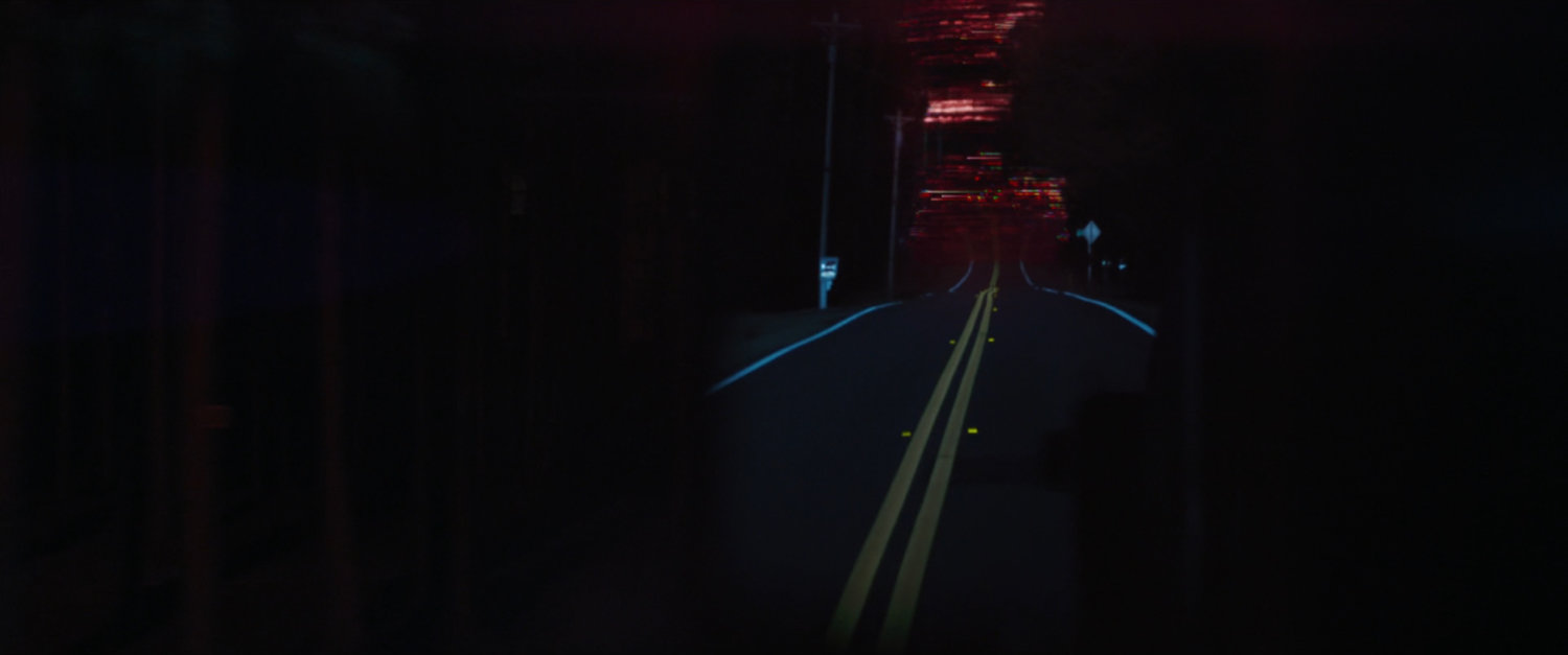 A red sky above a road at night.