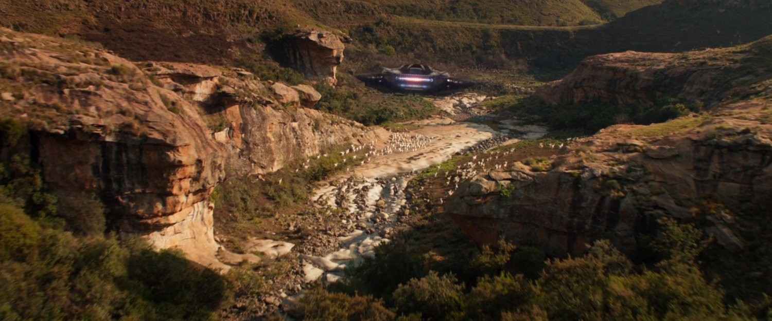 Talon fighter flying through a Wakandan valley.
