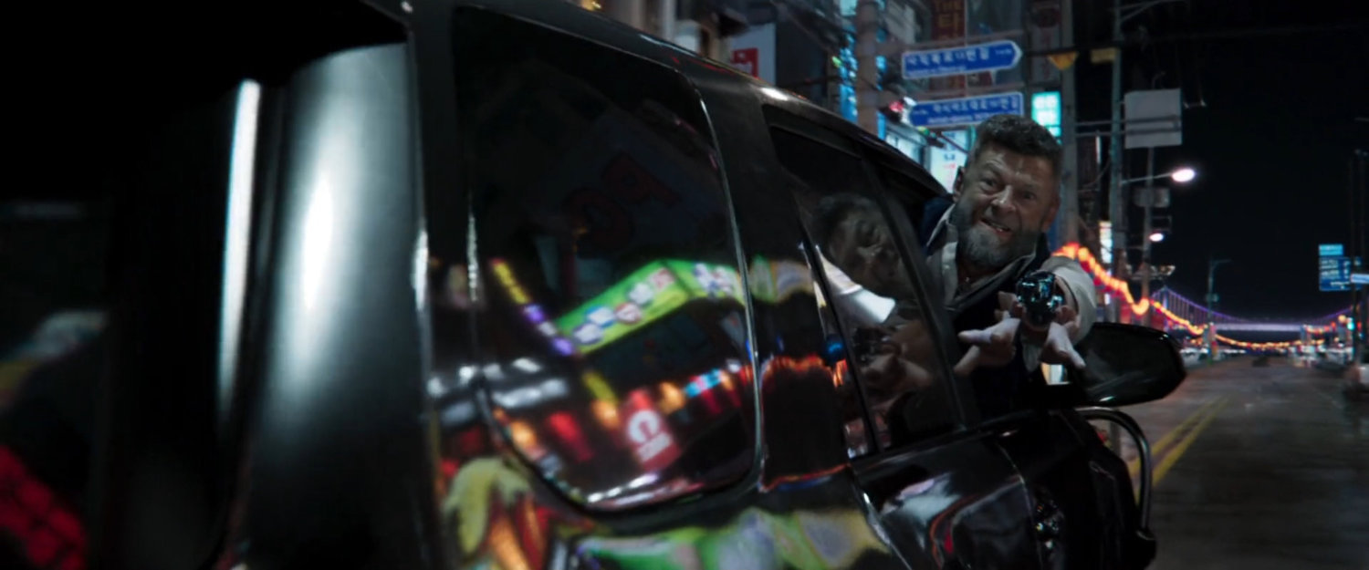 Close-up of Klaue leaning out of SUB window with arm outstretched.