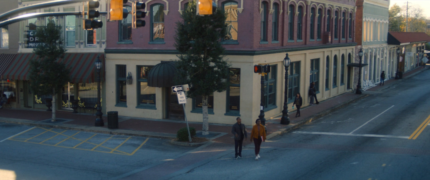 Sam and his sister cross the street outside the bank.