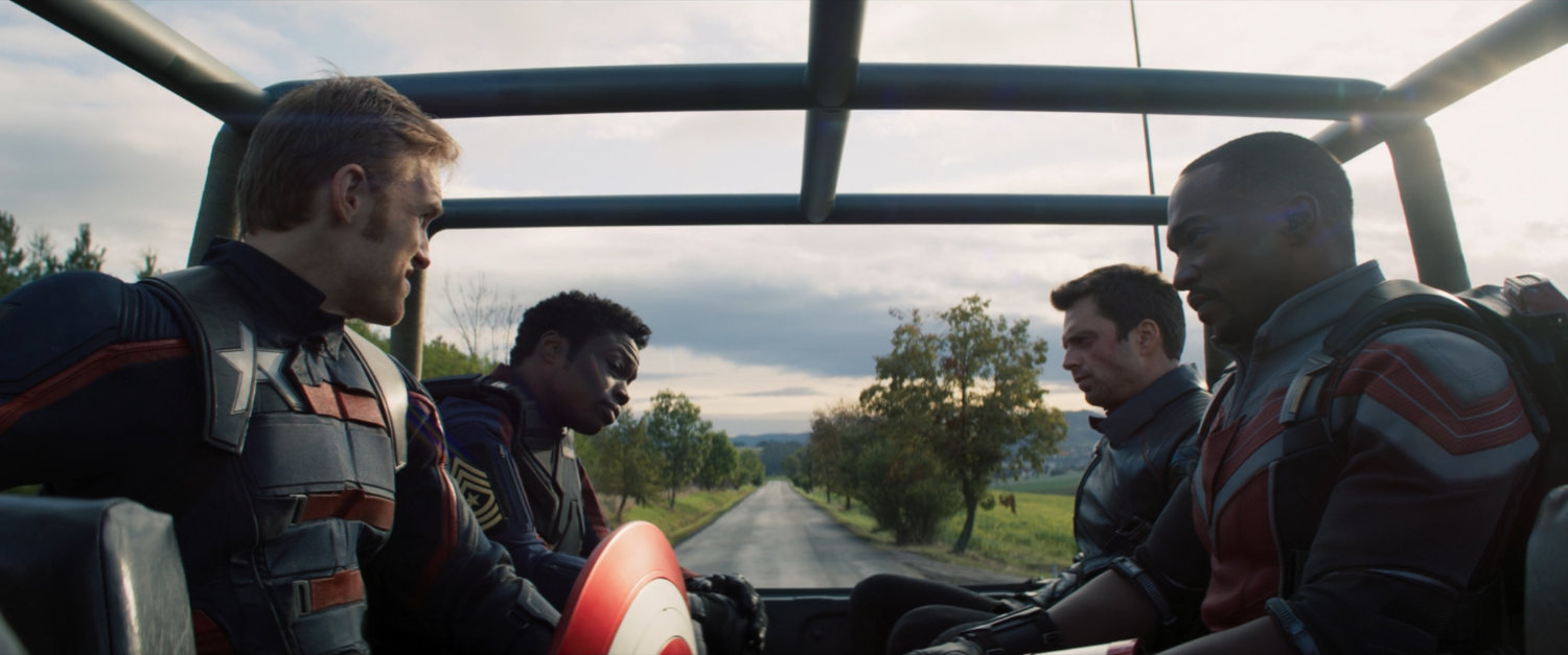 John and Lemar sit with Sam and Bucky in the back of a truck.