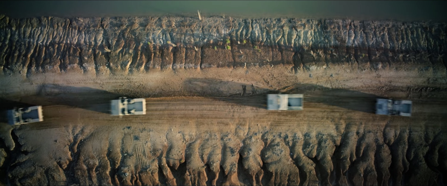 Aerial shot of humvees on desert road.