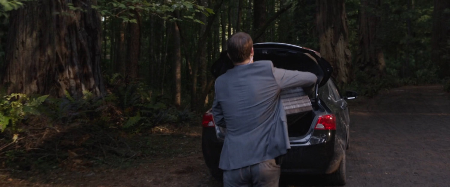 Sonny birch putting a shrunk Pym building in trunk of car.