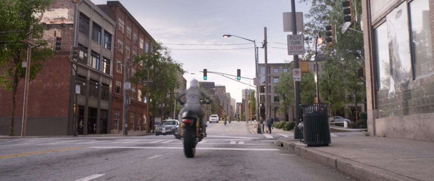 The Ghost drives away on a motorcycle.