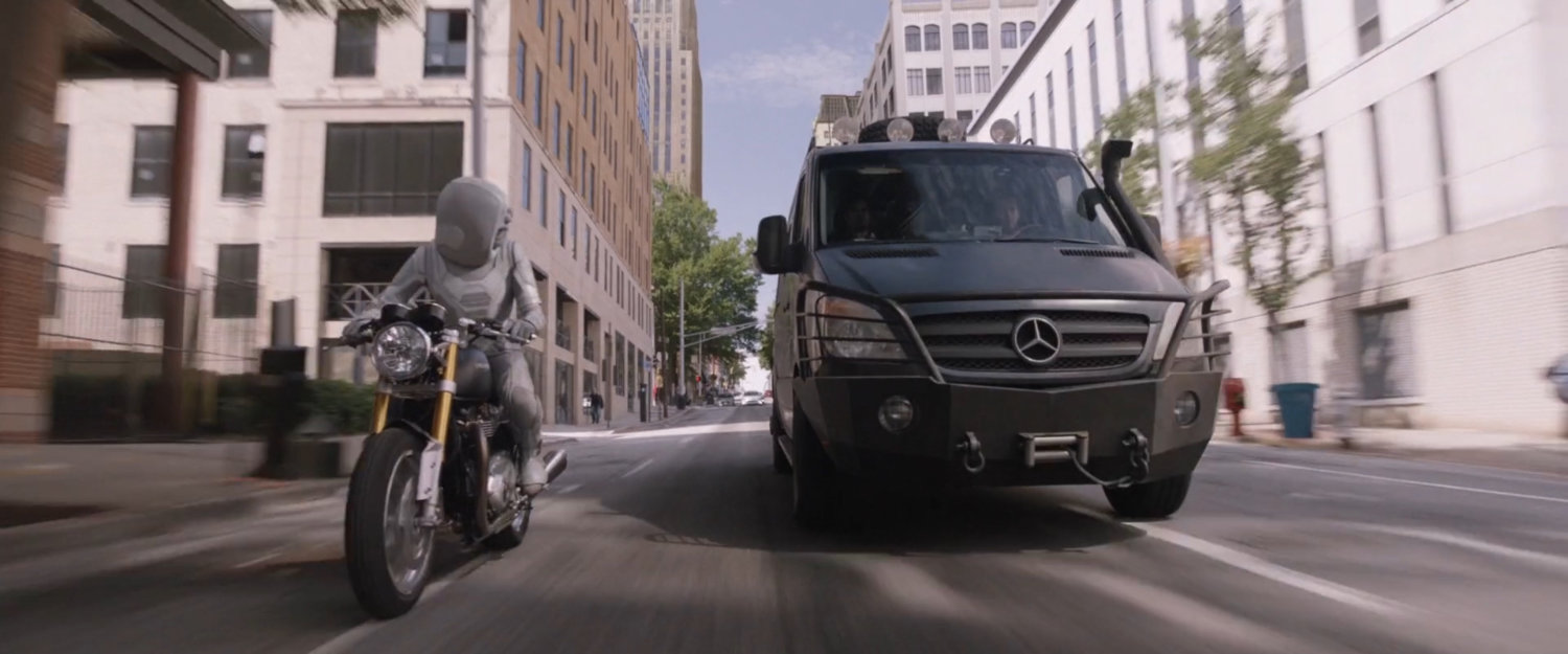 A van pull sup along side the Ghost on a motorcycle.
