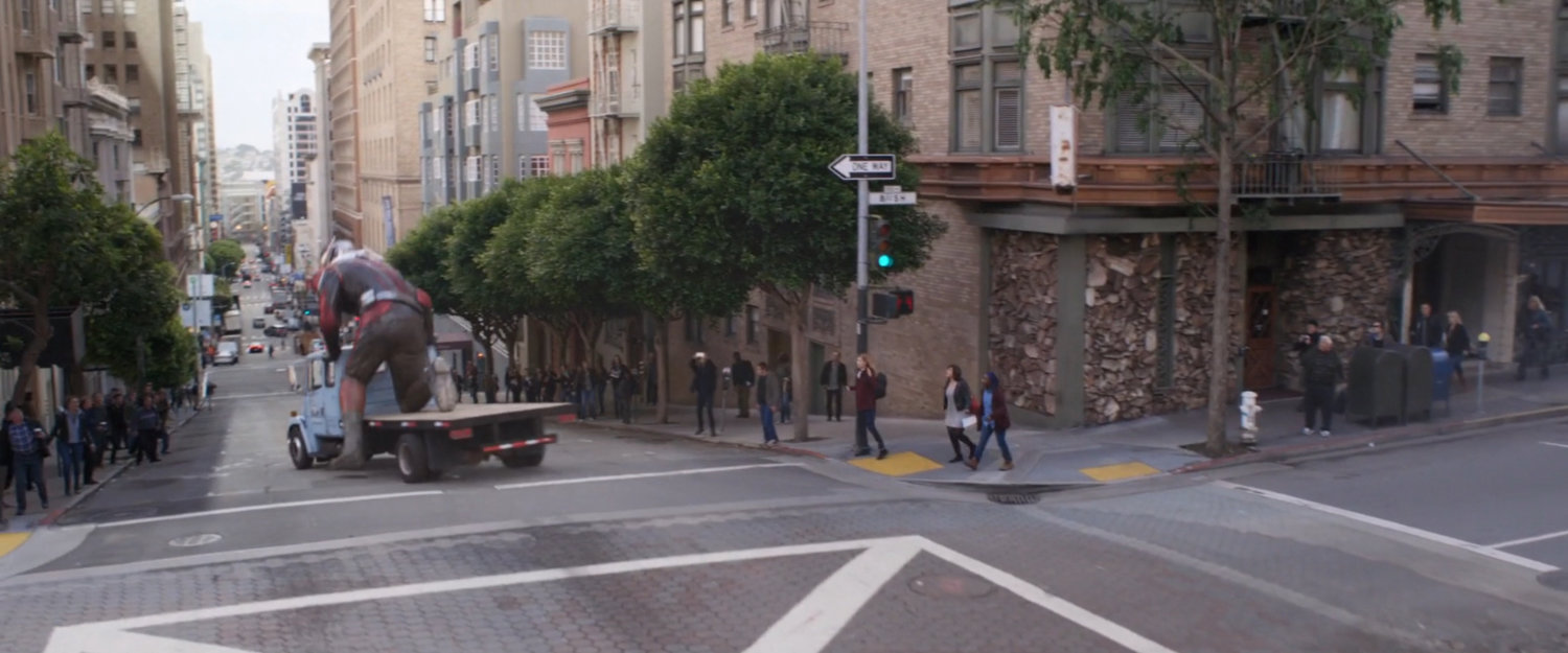 Giant-Man skates down hill using flatbed truck.