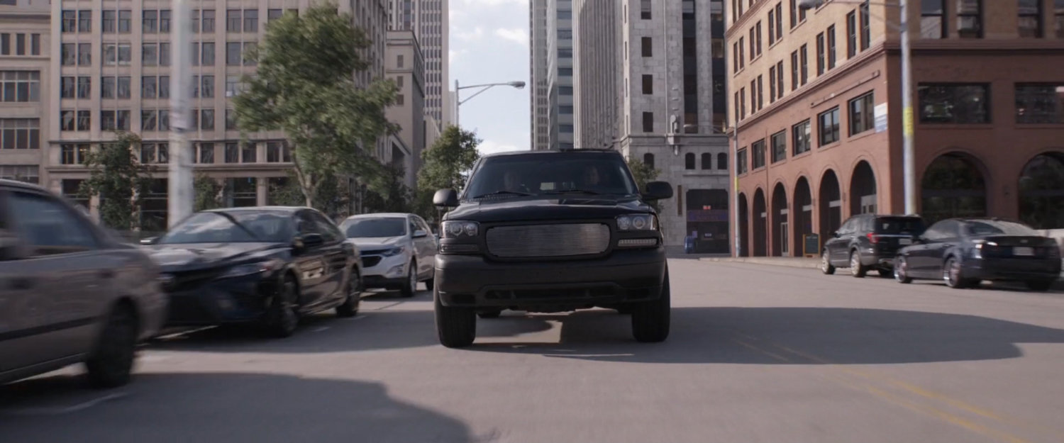 Black SUV speeding on a street.