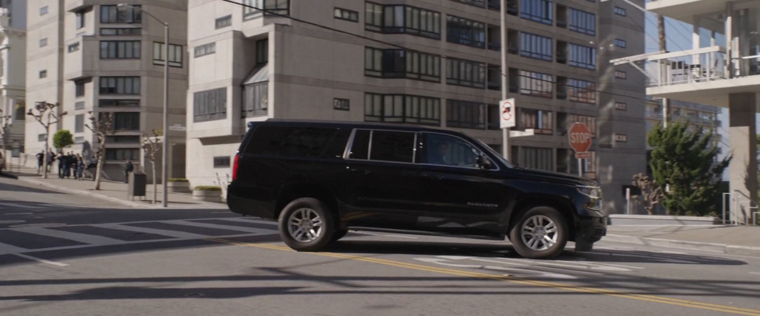 A black SUV stops in an intersection.