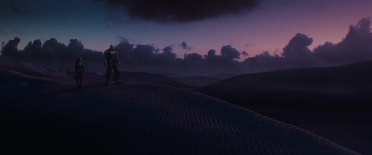 Gamora and Thanos silhouetted against a purple alien sky.