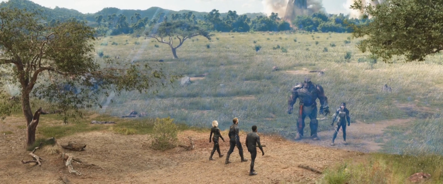 Three figures walk towards two aliens on a grassy plain.