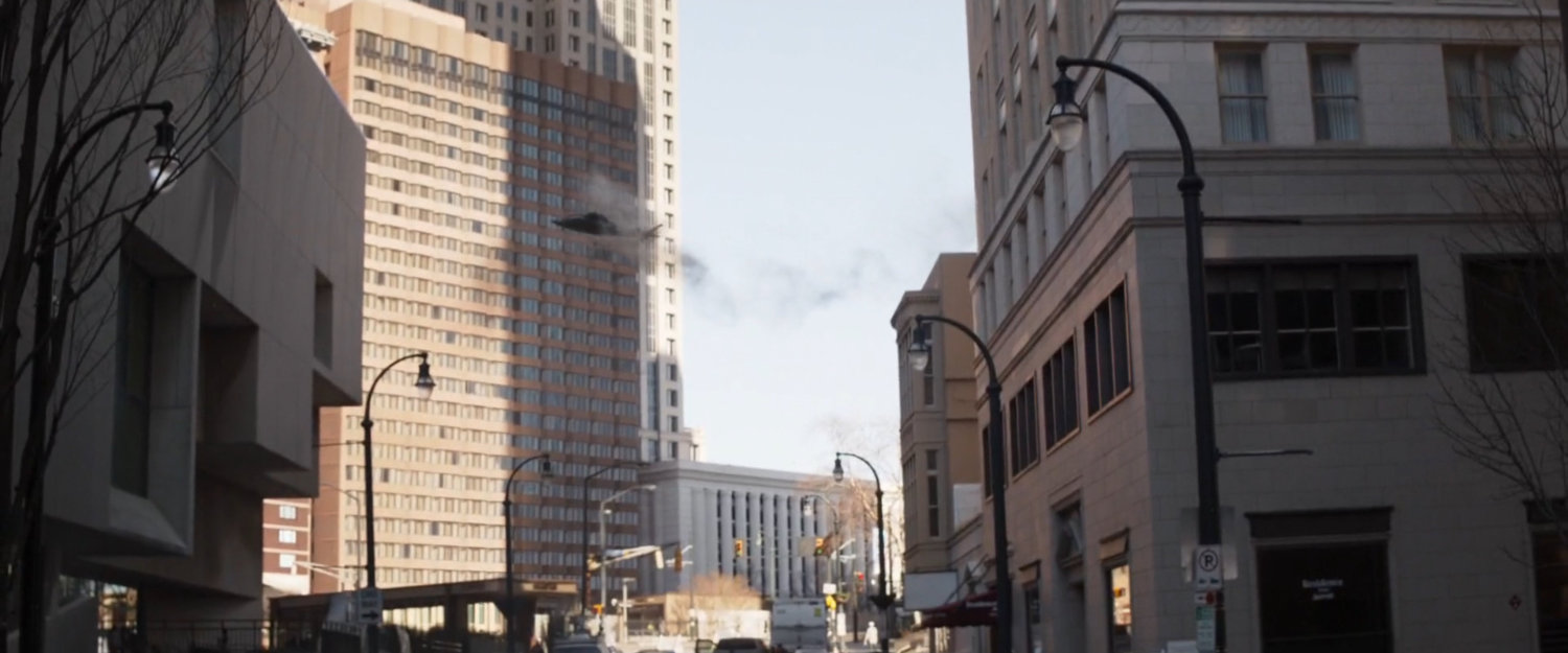 Smoking helicopter over city street.