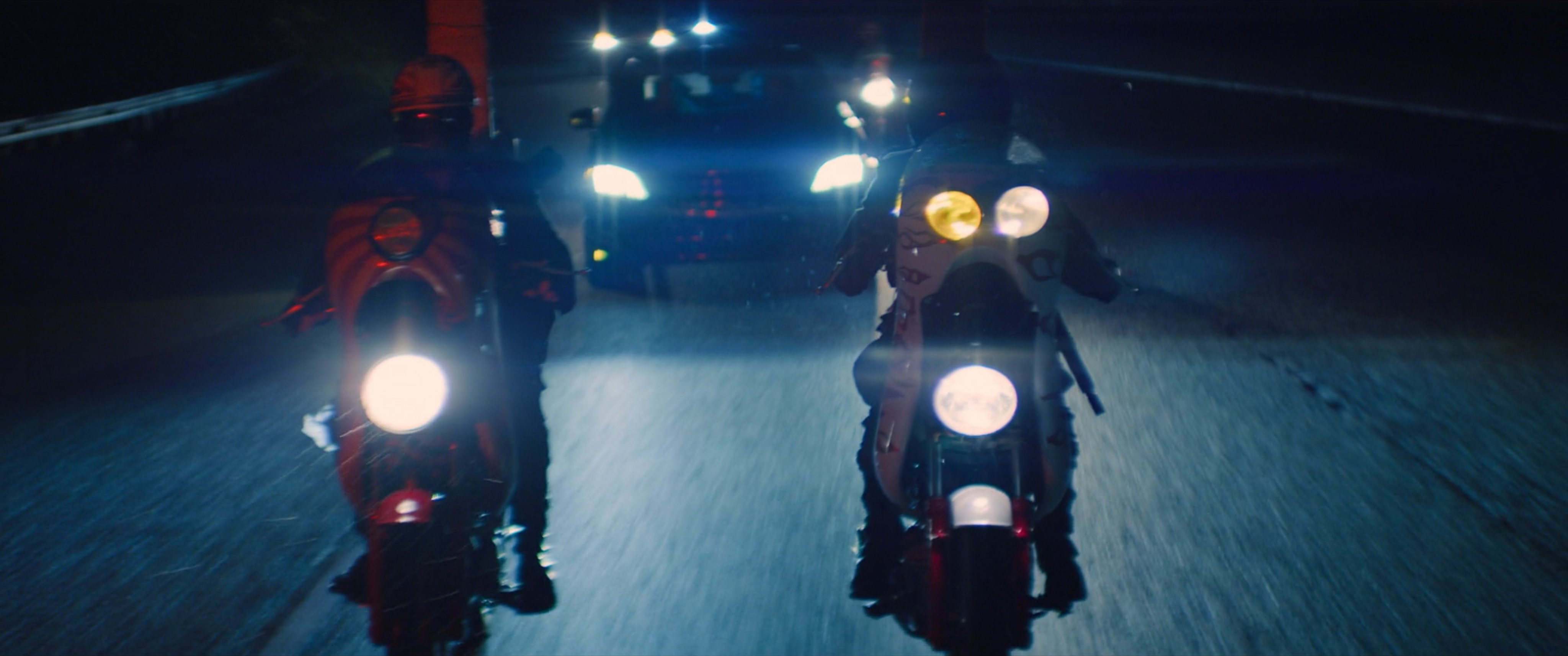 Vehicles on a rainy nighttime road heading towards Madripoor.