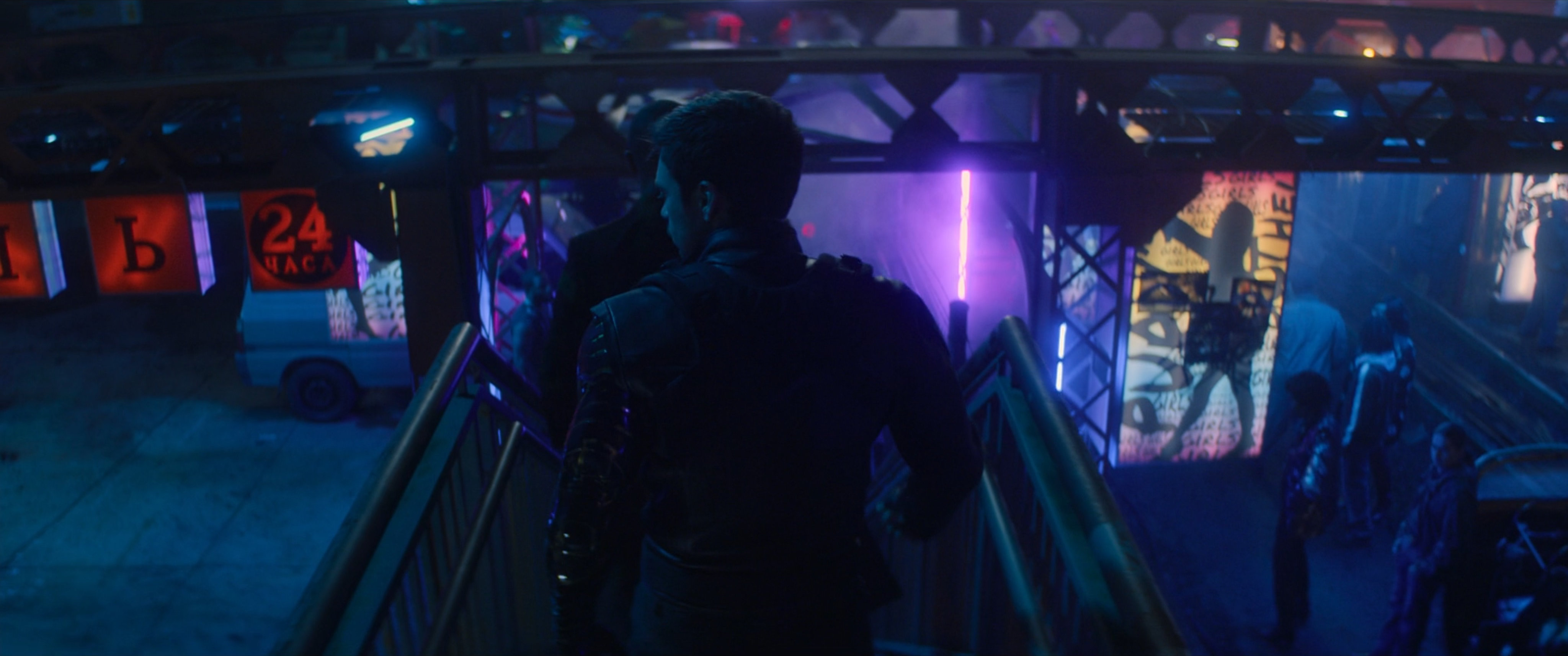 Bucky descends stairs in a crowded courtyard in low-town in Madripoor.