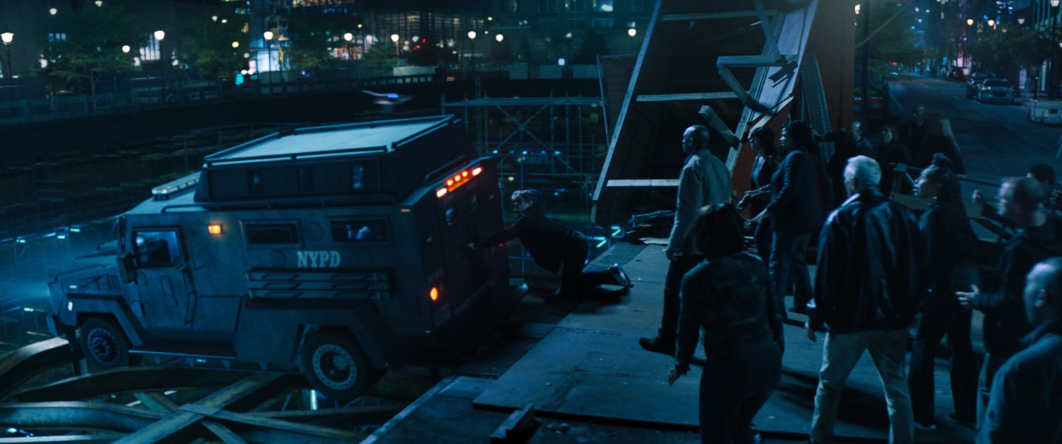 An armored car teetering on the edge of a construction hole.