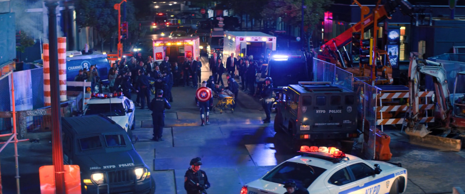 Sam Wilson stands before a number of emergency service personnel on a New York street.