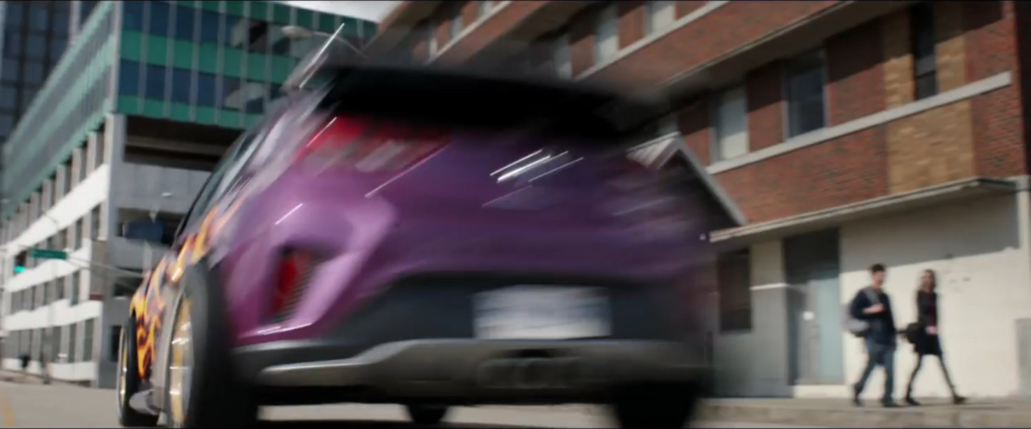 Original shot of purple car racing off towards corner from film trailer.