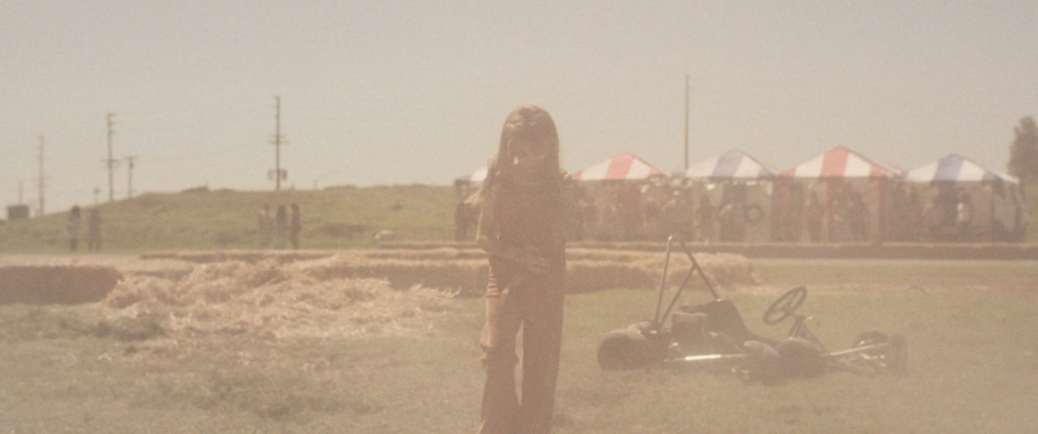 Young Carol Danvers brushes the dust off herself after a go cart crash.