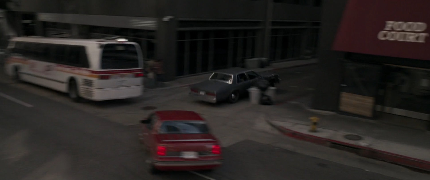Nick Fury's car races out of Los Angeles intersection, narrowly missing city bus.