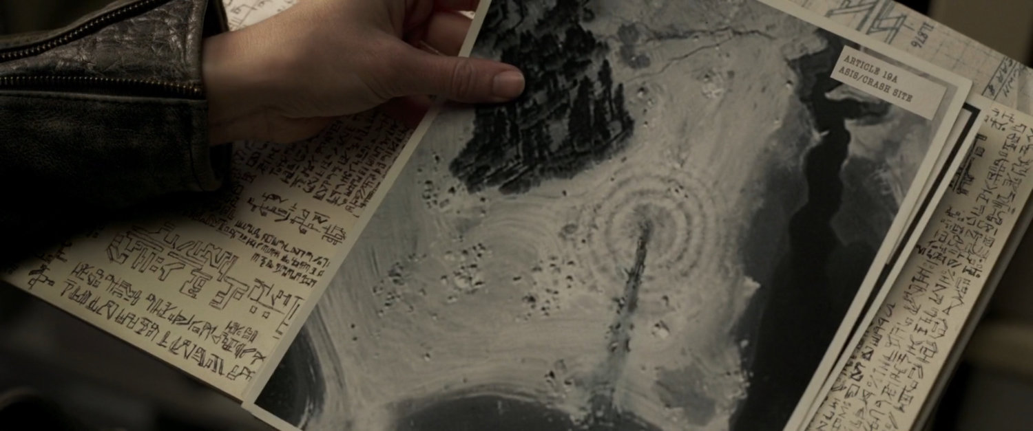 Hand holds aerial photograph of Asis crash site.