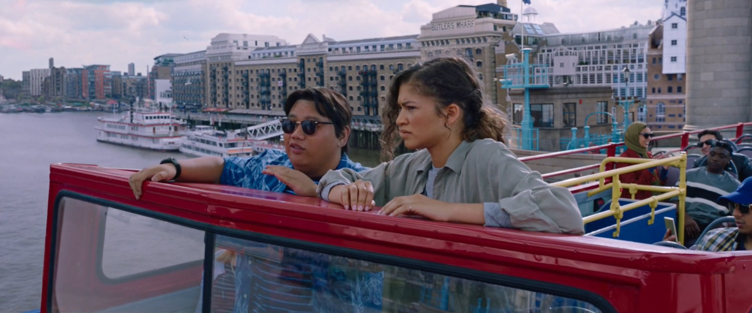 Ned and Michelle standing on top of double decker bus.