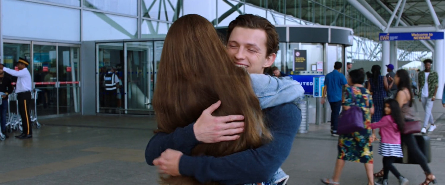 Aunt May hugs Peter outside Newark airport terminal.