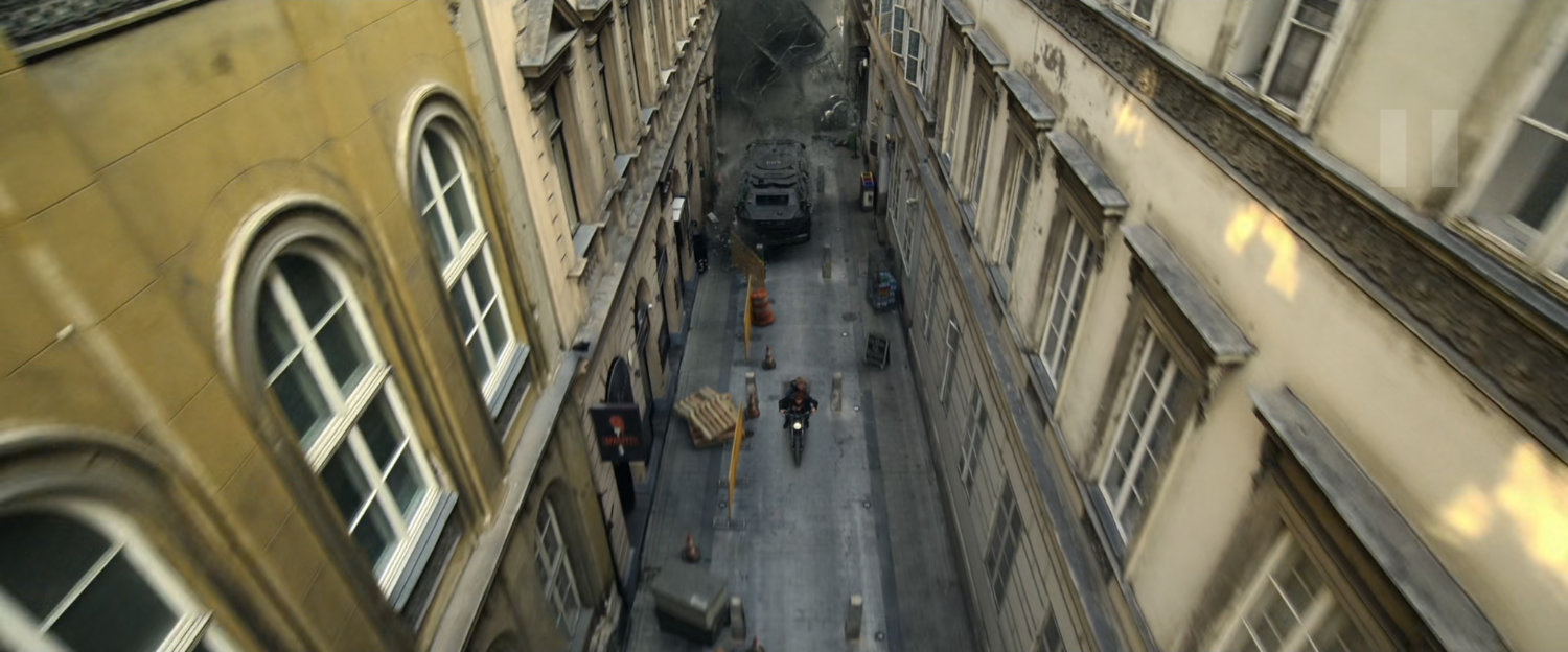 Motorcycle chased down Budapest alley by an APC.