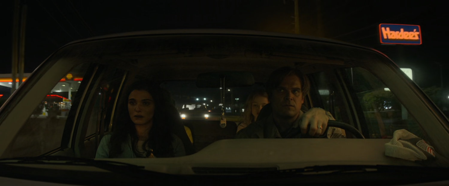 Alexei and Melina in family car with Hardee's sign outside.