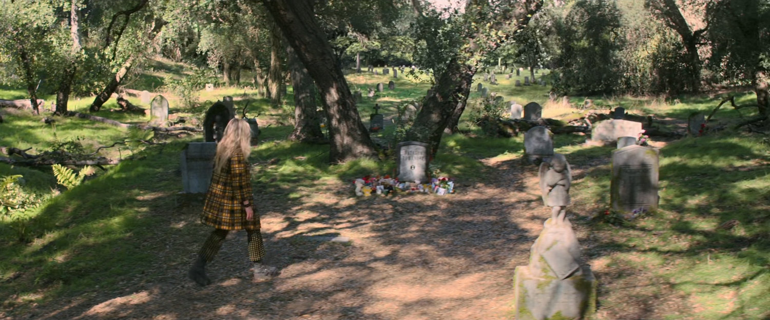 Yelena in a wooded cemetery.