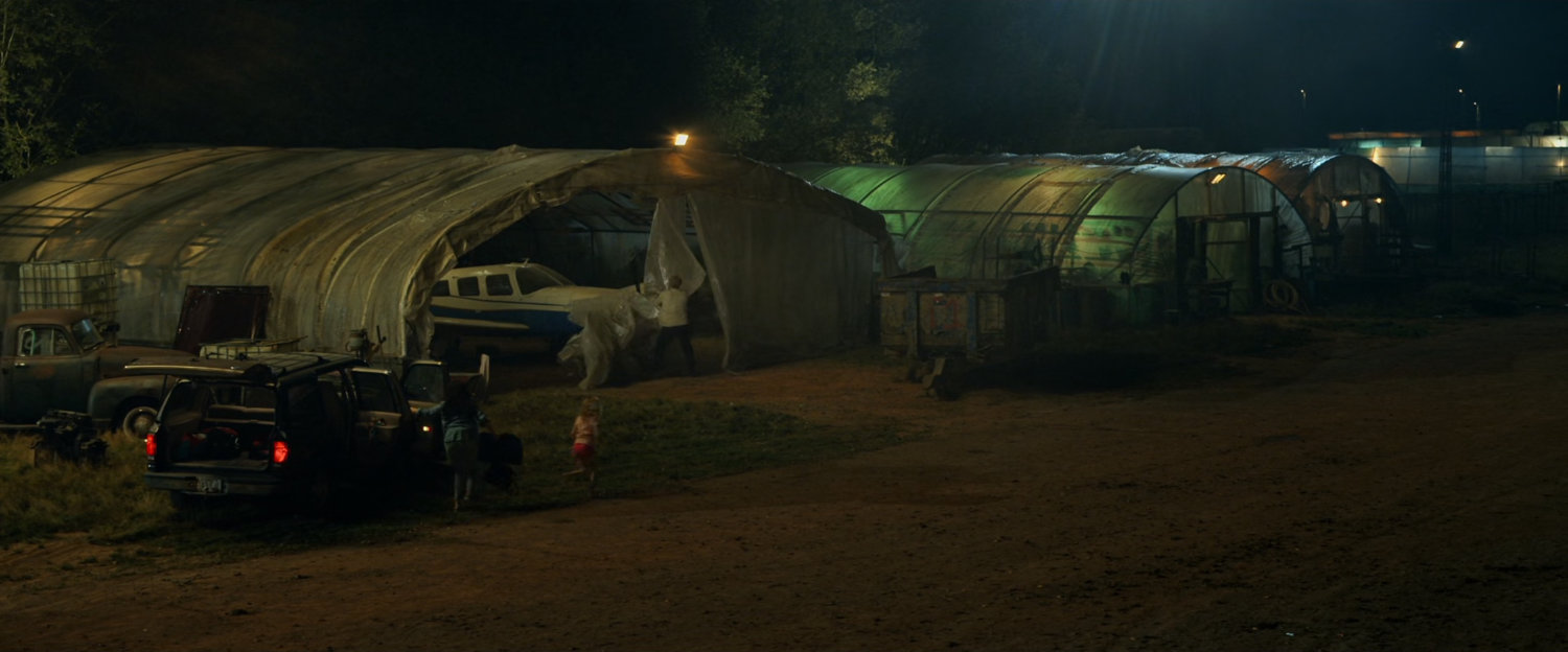 A Cessna inside a small plastic covered shed at a small airfield.