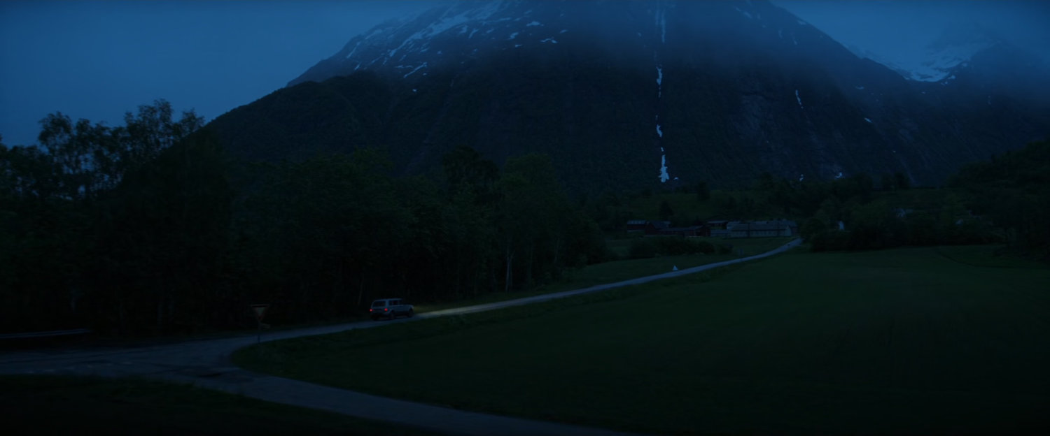 Car on Norwegian road at nighttime.
