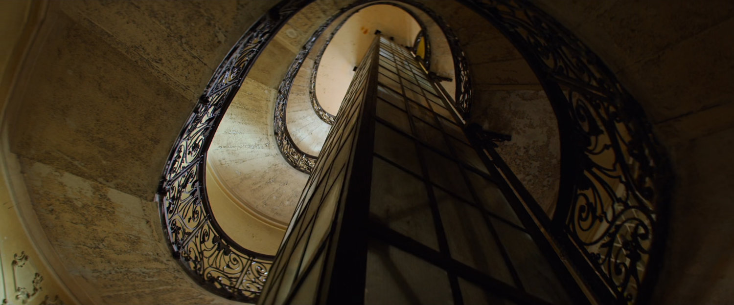 View up central staircase and elevator column in apartment building.