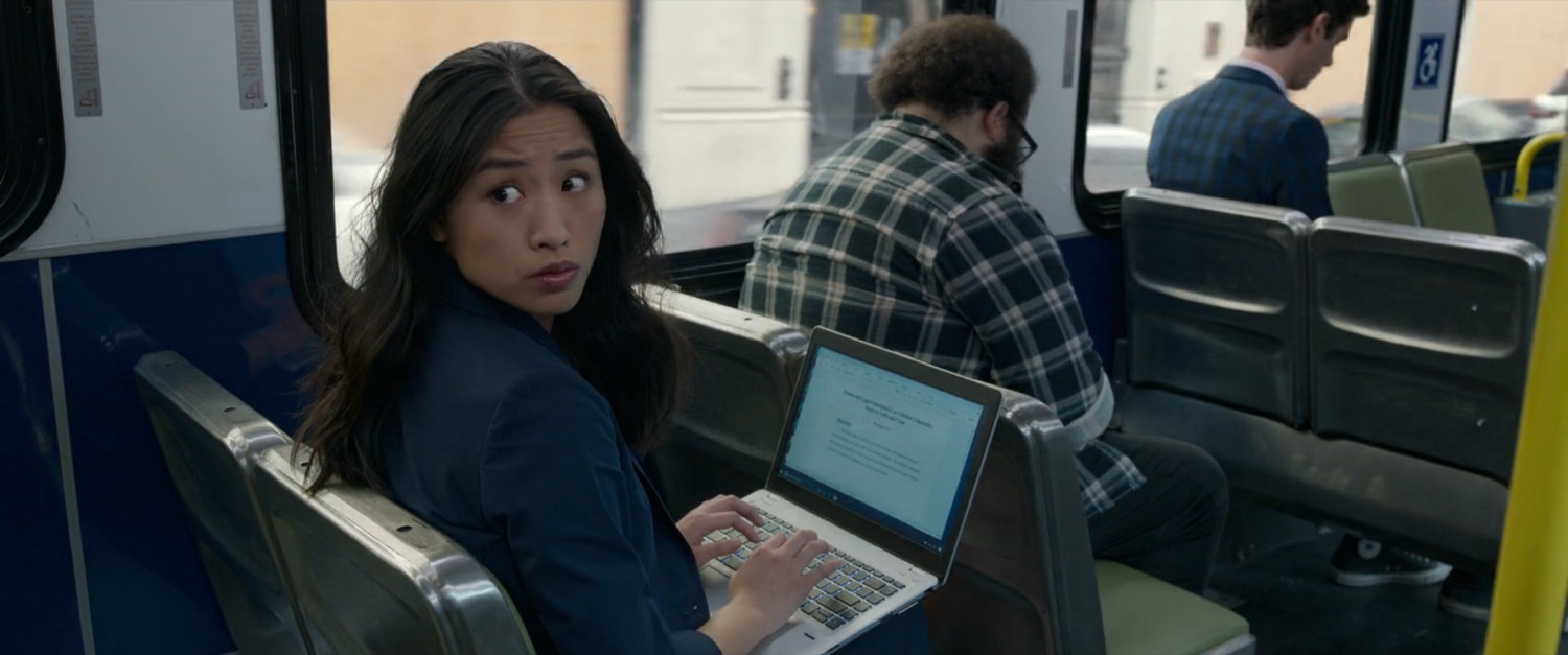 A woman with a laptop looking over her shoulder on a San Francisco metro bus.