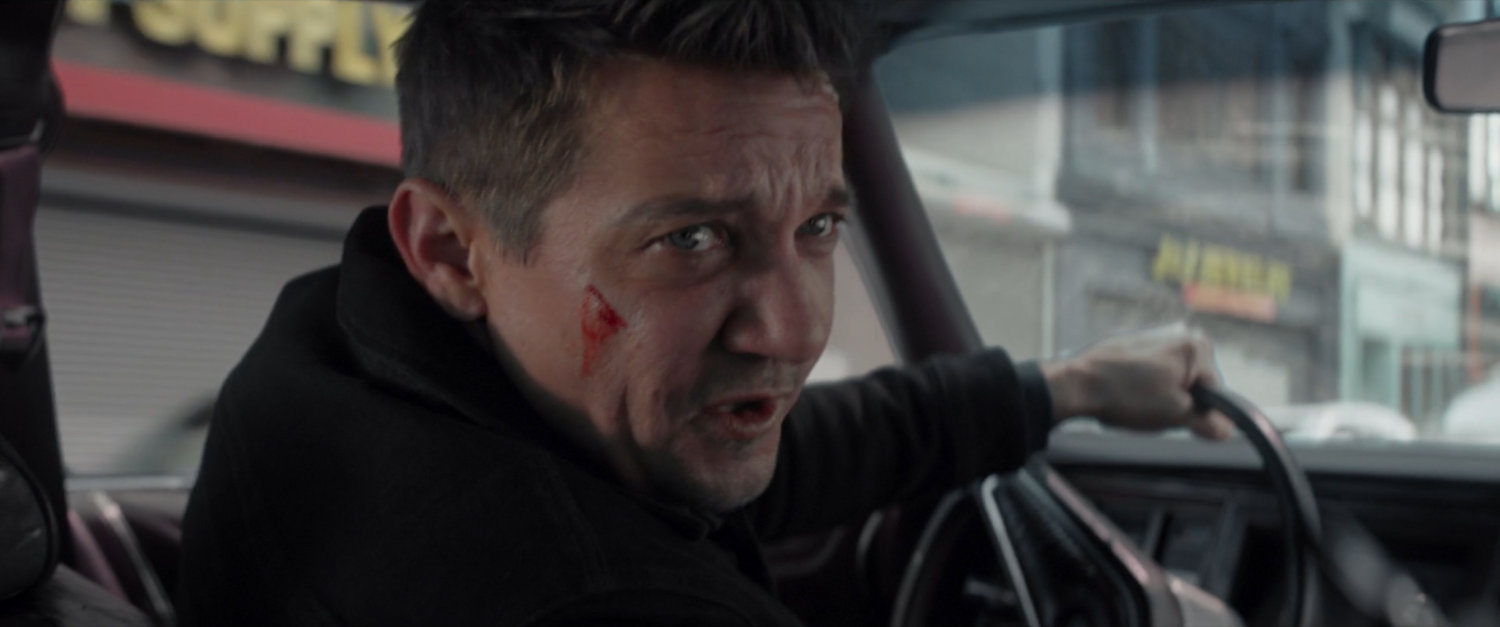 Clint driving a car through New York.